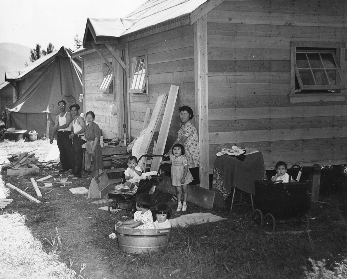 Japanese Canadian family stand outside internment shack