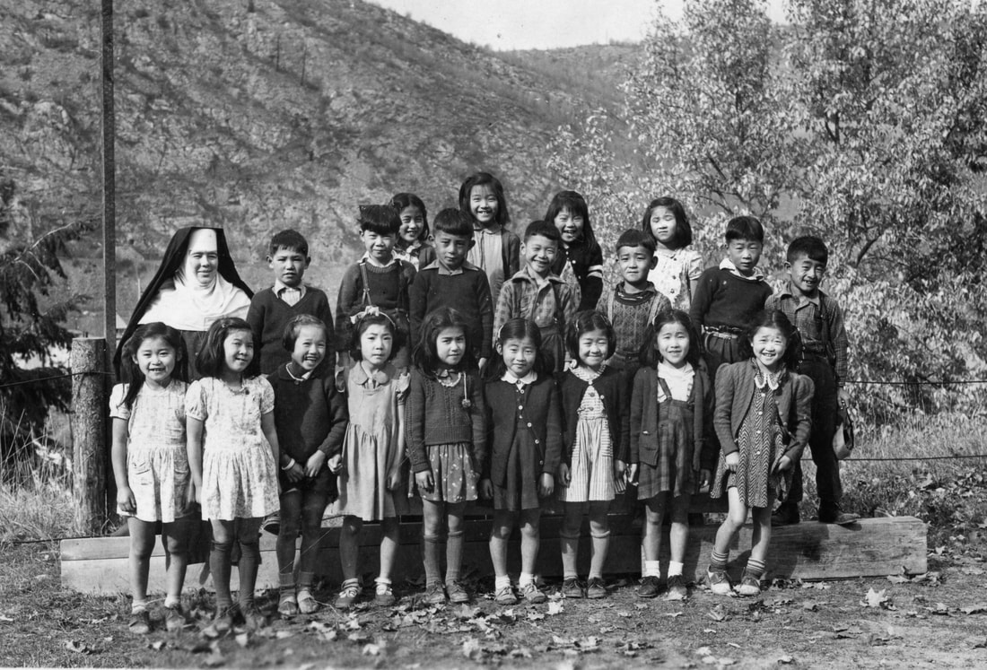 A nun poses with a class of 20 Japanese-Canadian children