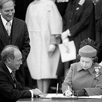 Trudeau and Queen Elizabeth signing constitution