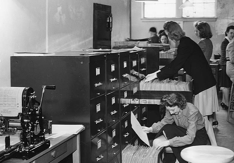 Office workers file documents in cabinets