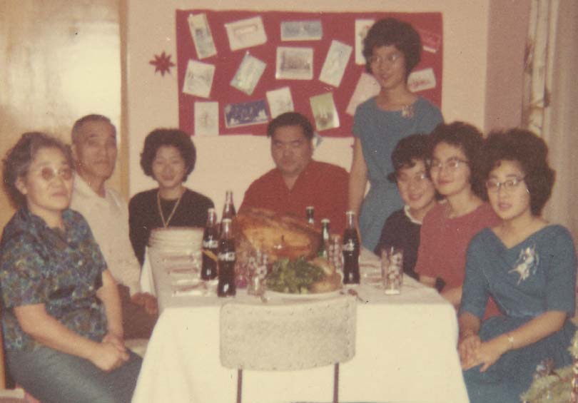 A Japanese Canadian family sits around Christmas dinner 1960s